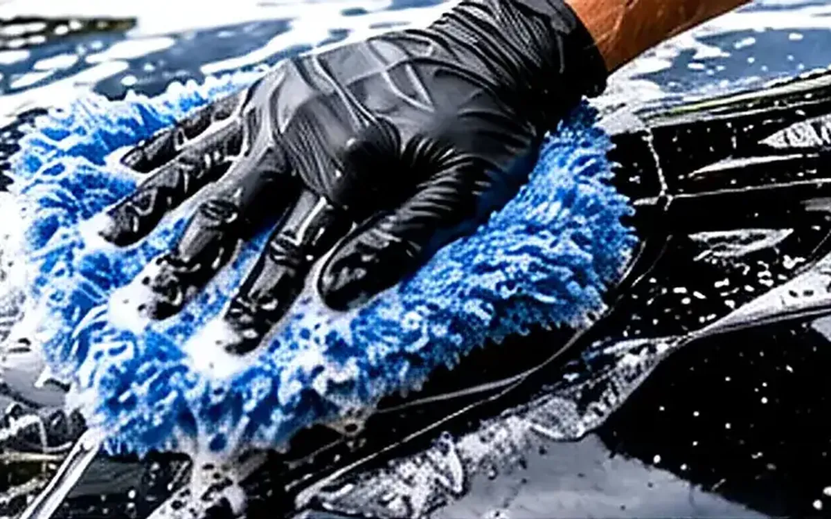Hand washing a vehicle panel with soap and a wash mitt